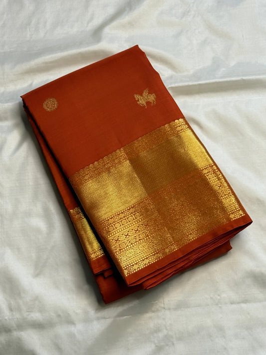 Earthy burnt-orange handwoven Pure Silk Kanjivaram Butta saree with gold zari buttas