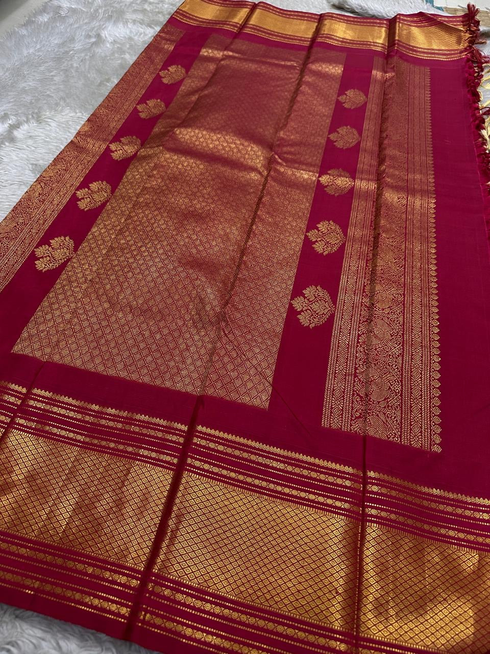 Wide pallu display of a Pure Kanchipuram silk saree with tomato red panels and gold zari woven motifs, shipped from New Jersey USA.