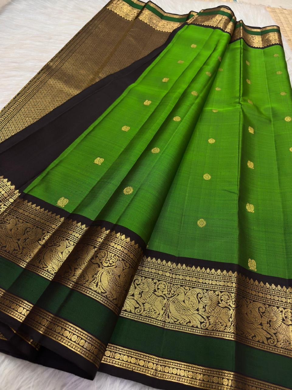 Gold peacock-and-floral scrollwork framed by dark silk and geometric seer rows