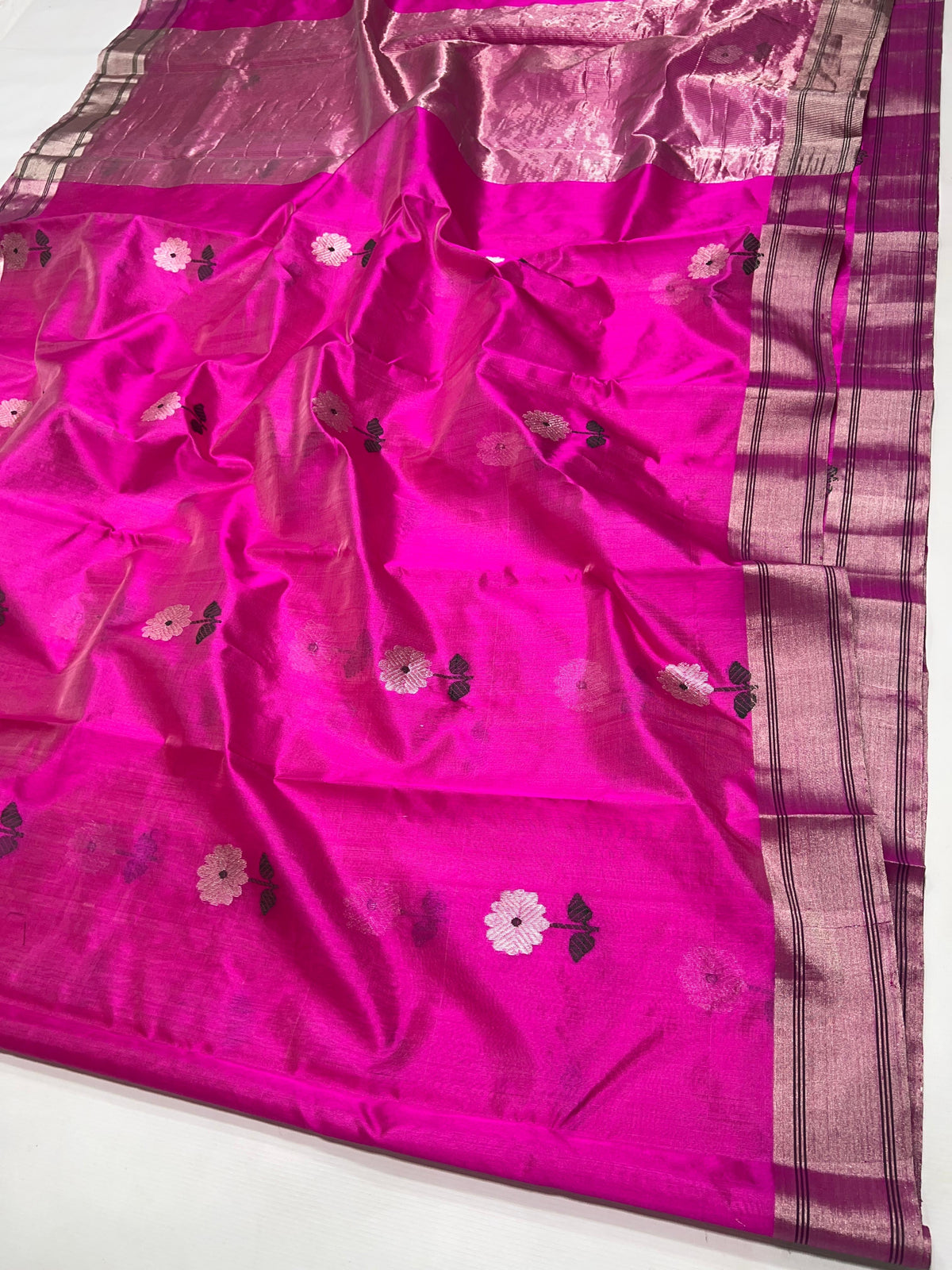 Pale floral buttas with deep green leaves woven on vivid pink Chanderi silk.
