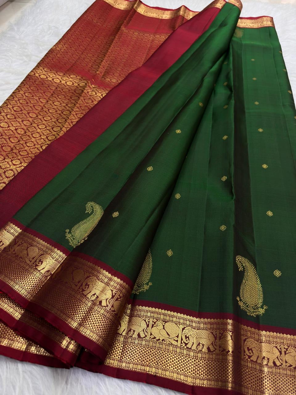 Pallu detail of the handwoven Kanchipuram saree: A richly patterned Arakku red pallu with dense gold zari and repeated geometric ornament.