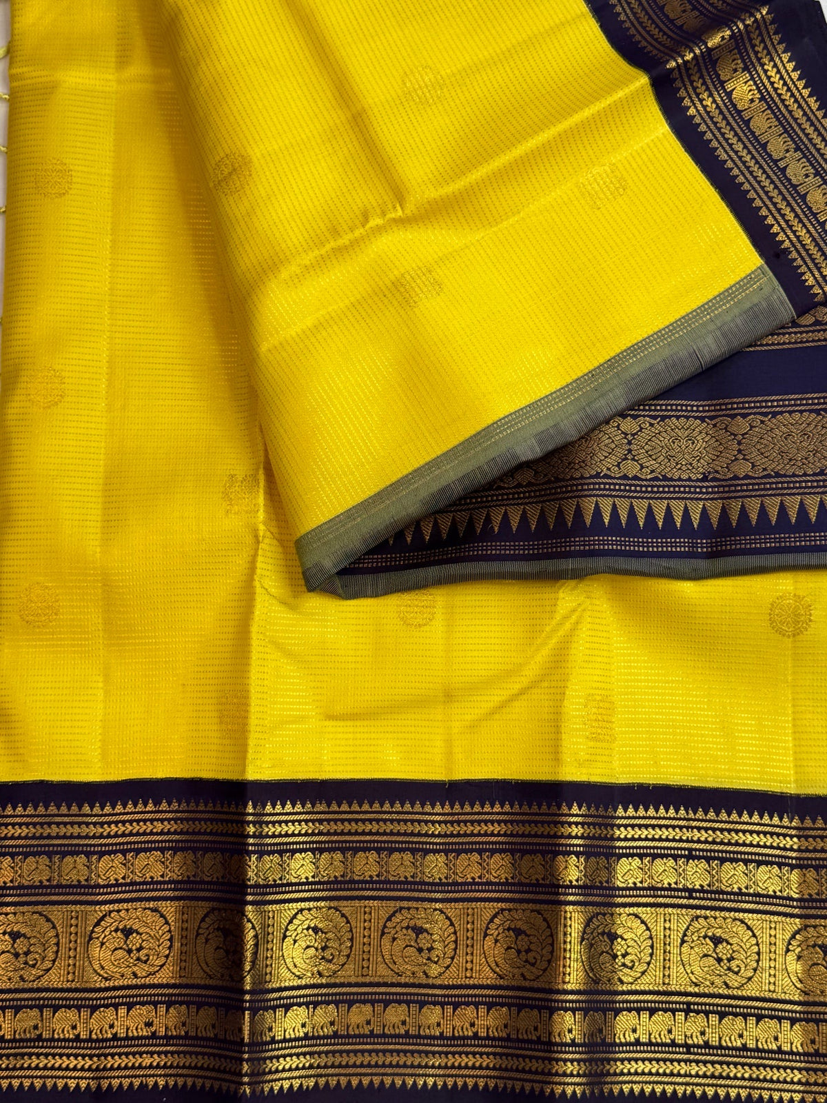 Close view of bright turmeric-yellow Kanjivaram silk showing closely placed Vairaoosi lines