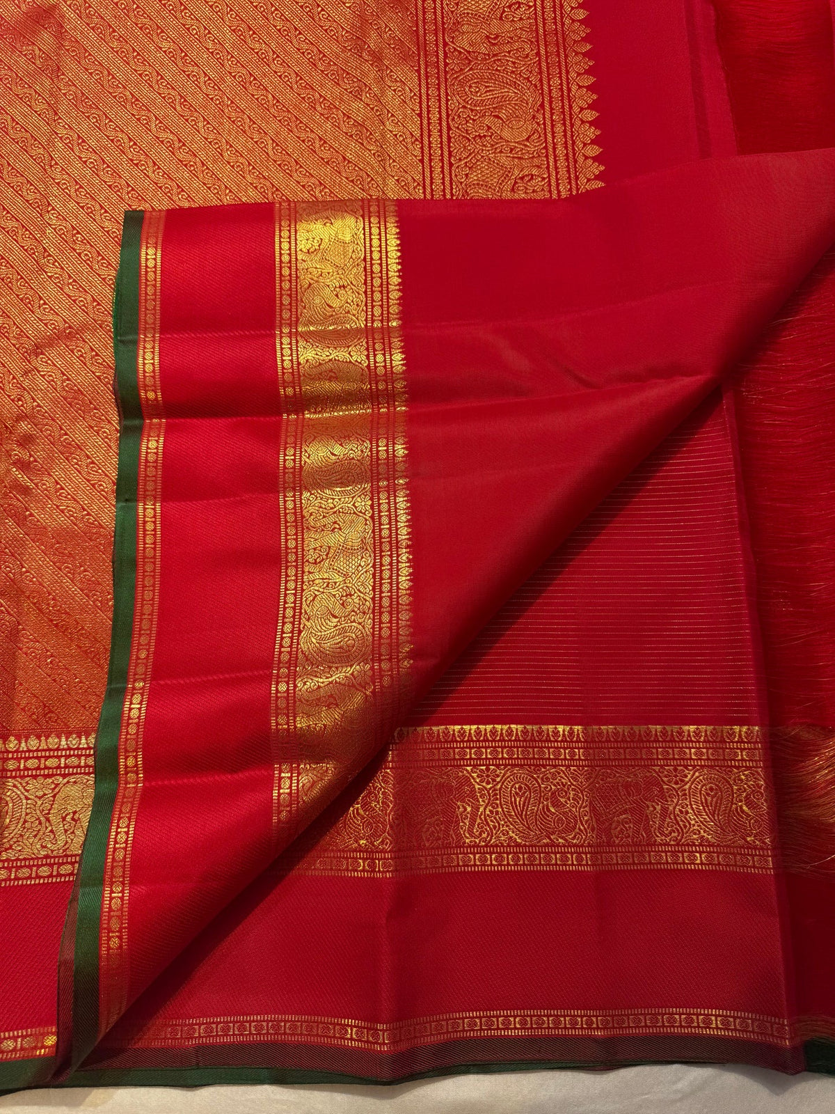 Maanga-inspired scrolling gold ornament in the border.