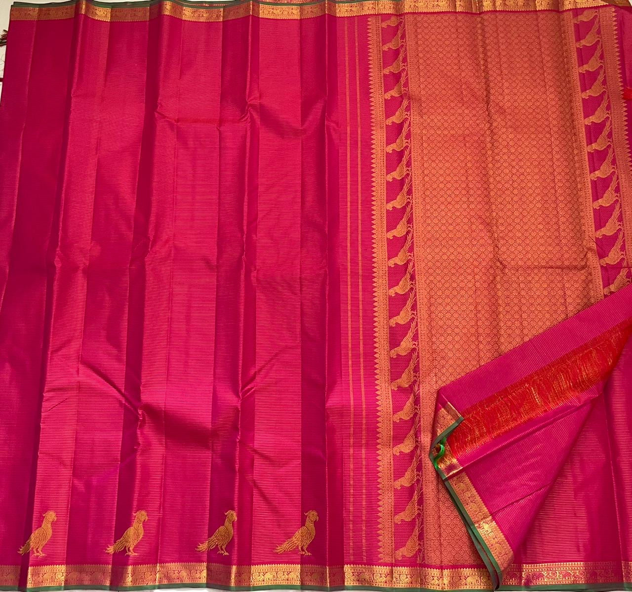 Detail of fine Vairaoosi zari lines woven continuously across hot pink Kanchipuram pure silk body