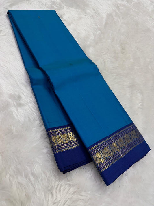 Ink blue Pure Kanchipuram Silk Saree drape with navy zari border and gold zari pattern on white fur background