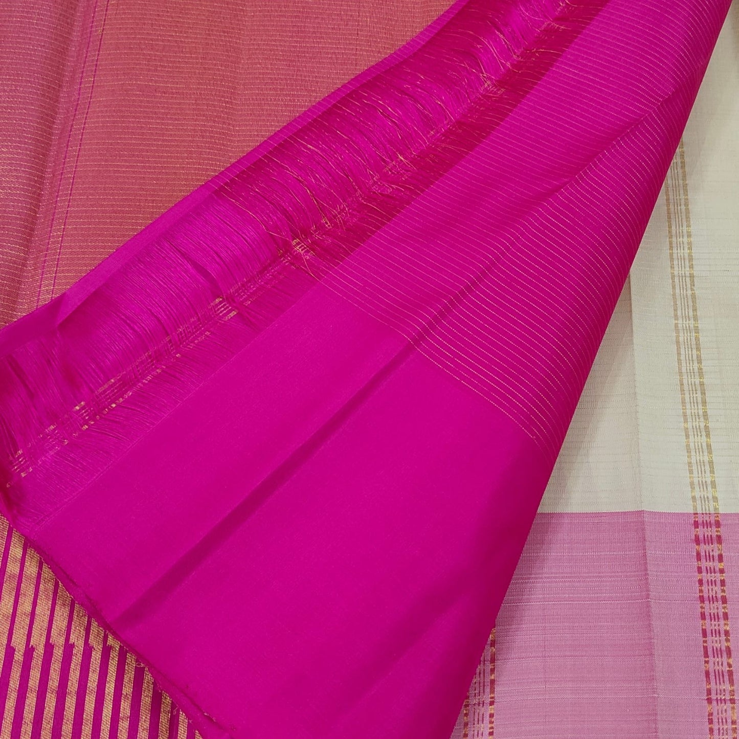 Folded ivory beige Ettukol Kanjeevaram silk saree showing temple border