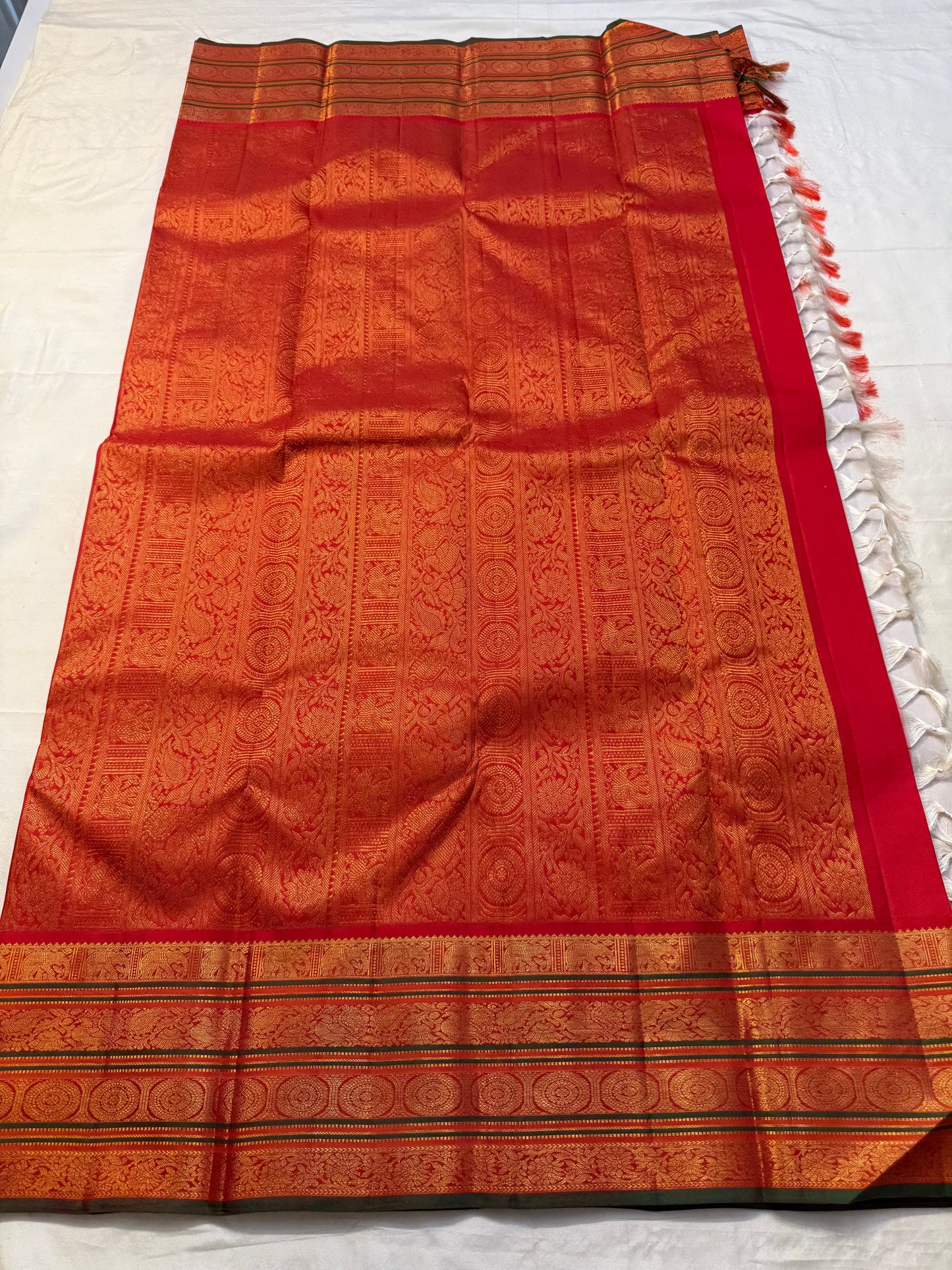 Full zari pallu laid flat with red border and tassels on Pure Kanchipuram Silk Saree, available in the USA