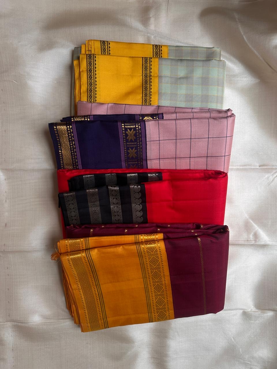 Stack of colorful folded fabrics on a light gray background