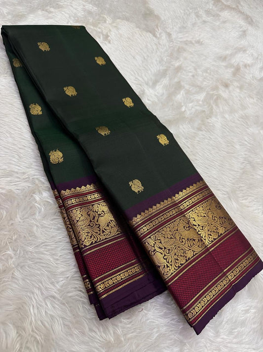 Deep pine green Kanchipuram silk saree with mulberry purple border folded view