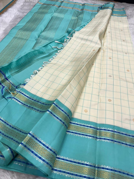 Soft pink Kanjivaram silk saree with fine checkered pattern and deep navy contrast border detail
