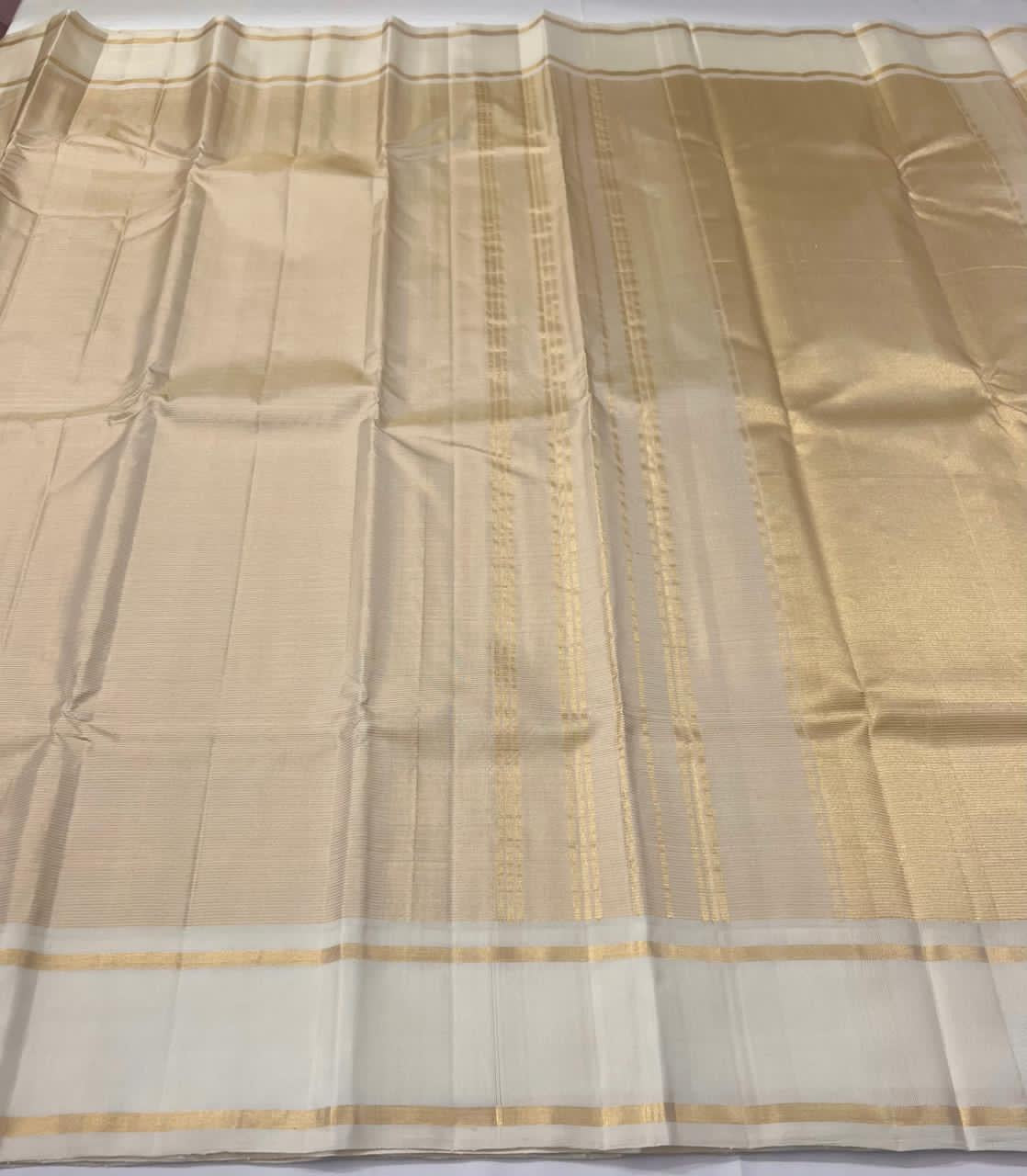 Kanchipattu silk saree soft gold accent border close up on cream silk
