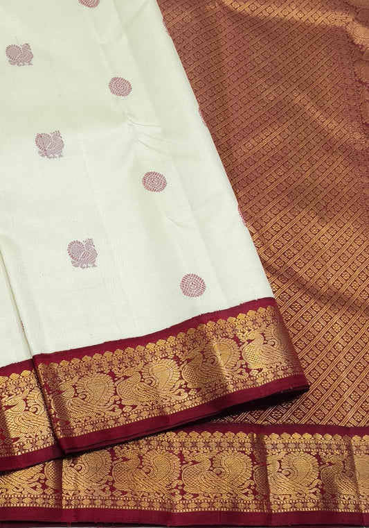Kanjivaram silk saree cream base with maroon contrast border and maanga butta motifs