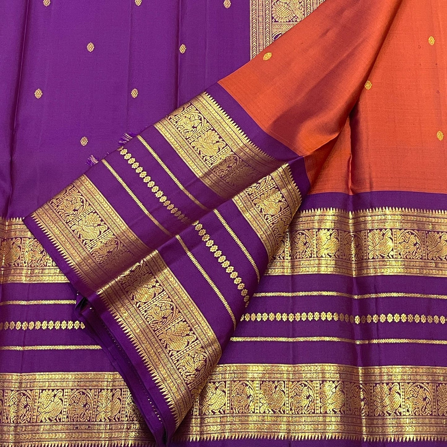 Pure silk Kanchipuram saree with purple body, rust-orange contrast and gold zari.