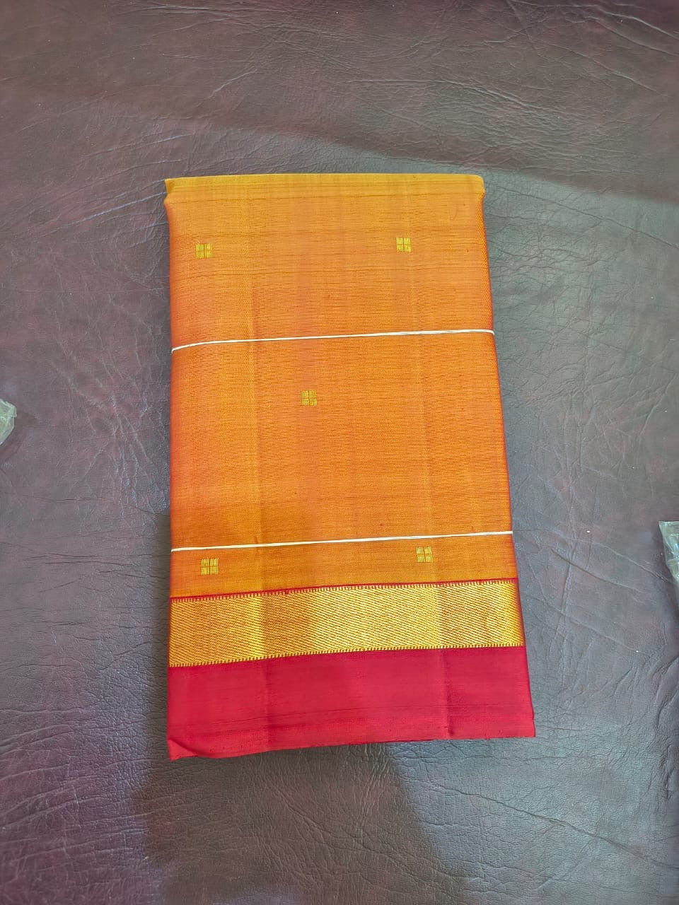 orange Kanchipuram silk saree with ls weave folded view