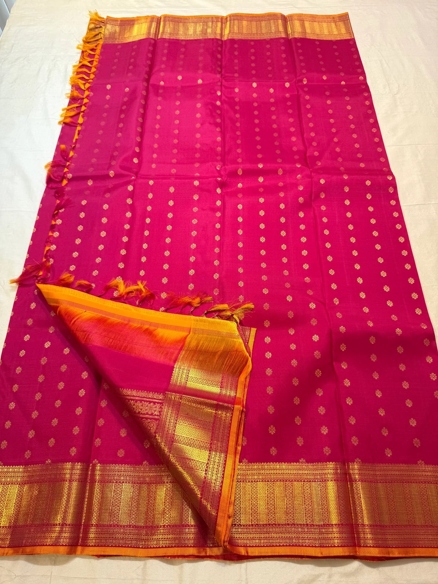Wide golden zari geometric border on magenta Kanchi Pattu saree