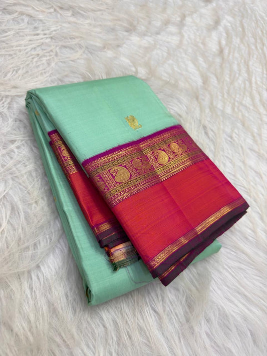Mint-green Korvai saree showing Vadamalli-purple, coral-orange and gold-zari contrast border.