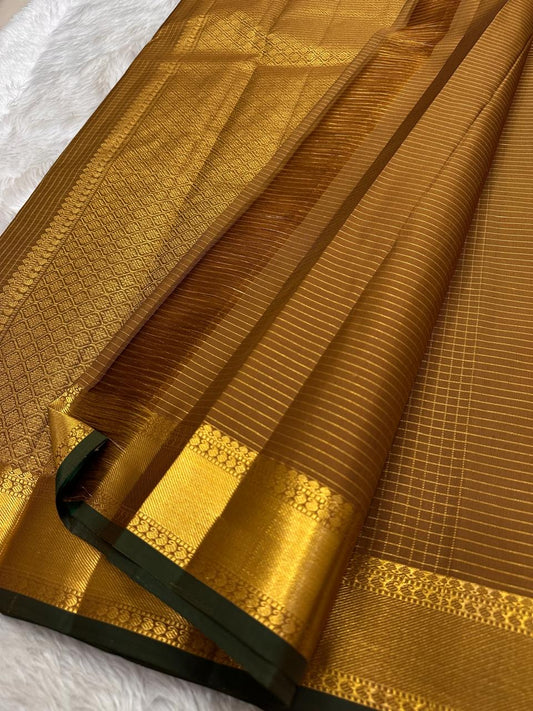 Thick antique gold zari woven border with floral and geometric motifs on mustard amber Kanchi Pattu saree
