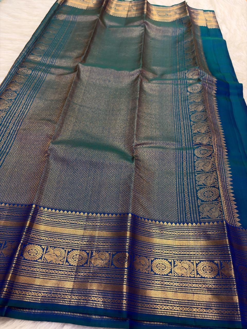 Peacock Blue Thazampoo Reku pure silk Kanchipuram saree, border zari, showing deep oceanic peacock blue with a teal-green glimmer, royal blue border accents and antique-gold zari