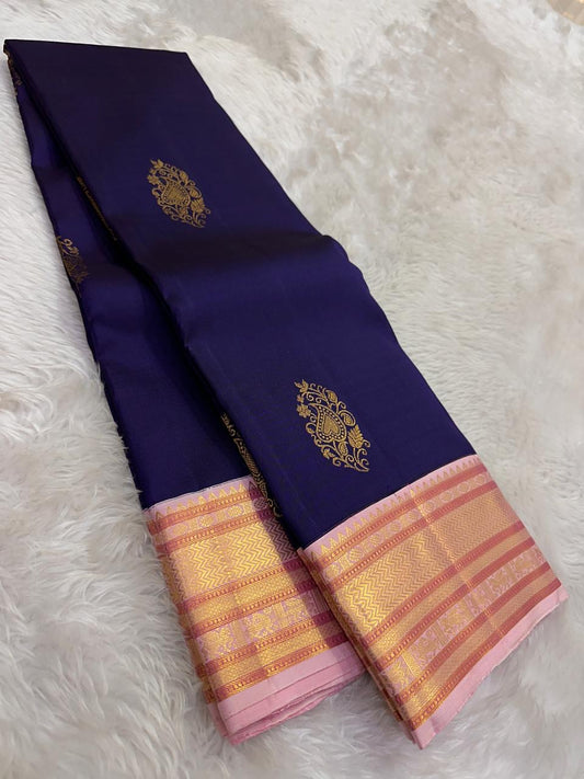 Deep navy Pure Silk Kanchipuram varisaipet saree with lotus-pink border and layered zari detailing.