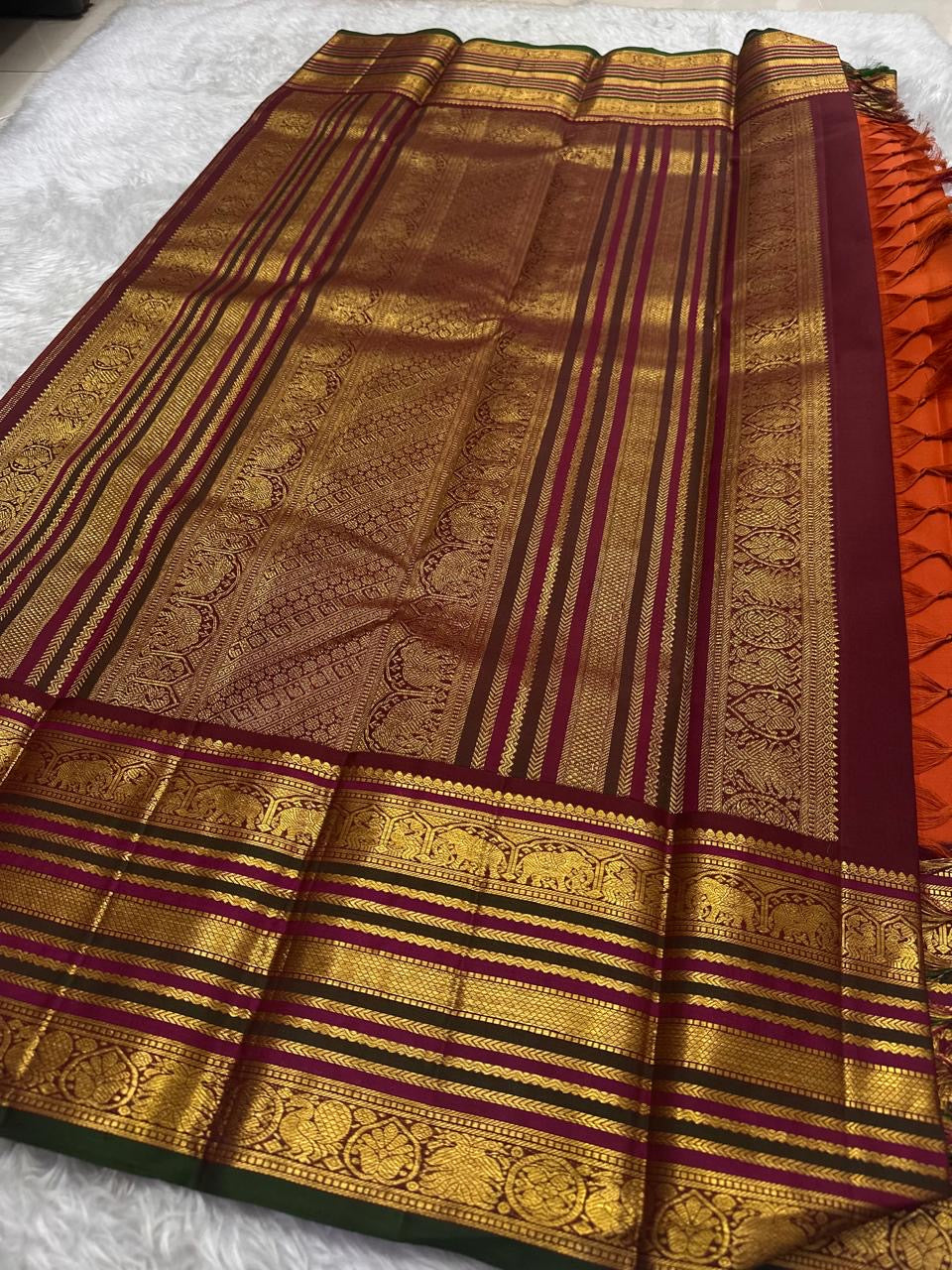 Magenta and black Varisaipet border with elephant procession and floral zari bands in antique gold