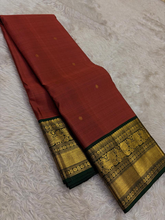 Warm rust Kanjivaram silk saree with traditional gold zari weaving