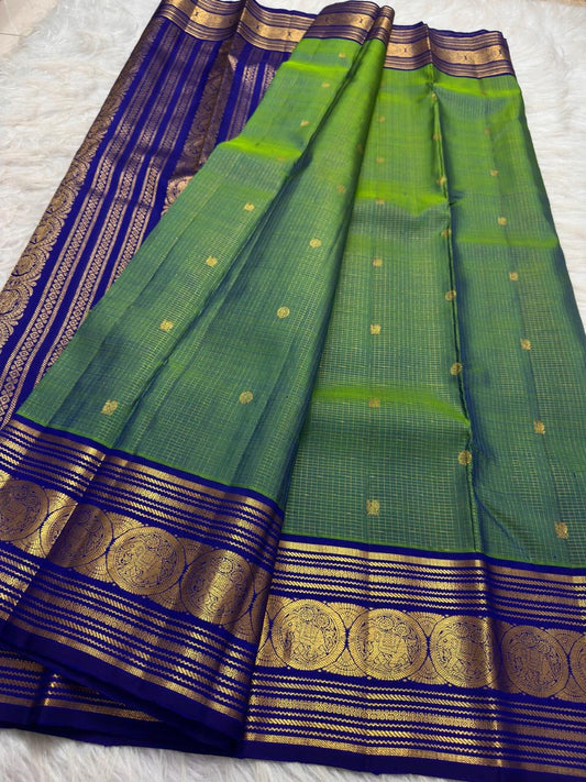 Fine gold Zari Kattam checks and buttas across the parrot green silk body