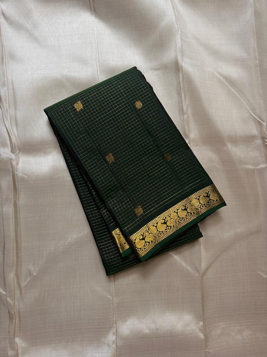 Dark bottle green Kanjipuram silk saree body close-up showing Zari Kattam luminous grid with Pavun coin antique gold zari butta motifs