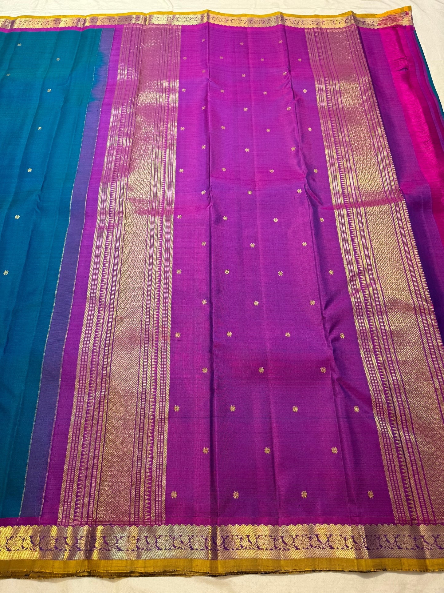 Magenta petite border with fine gold zari edge on peacock blue Kancheepuram saree