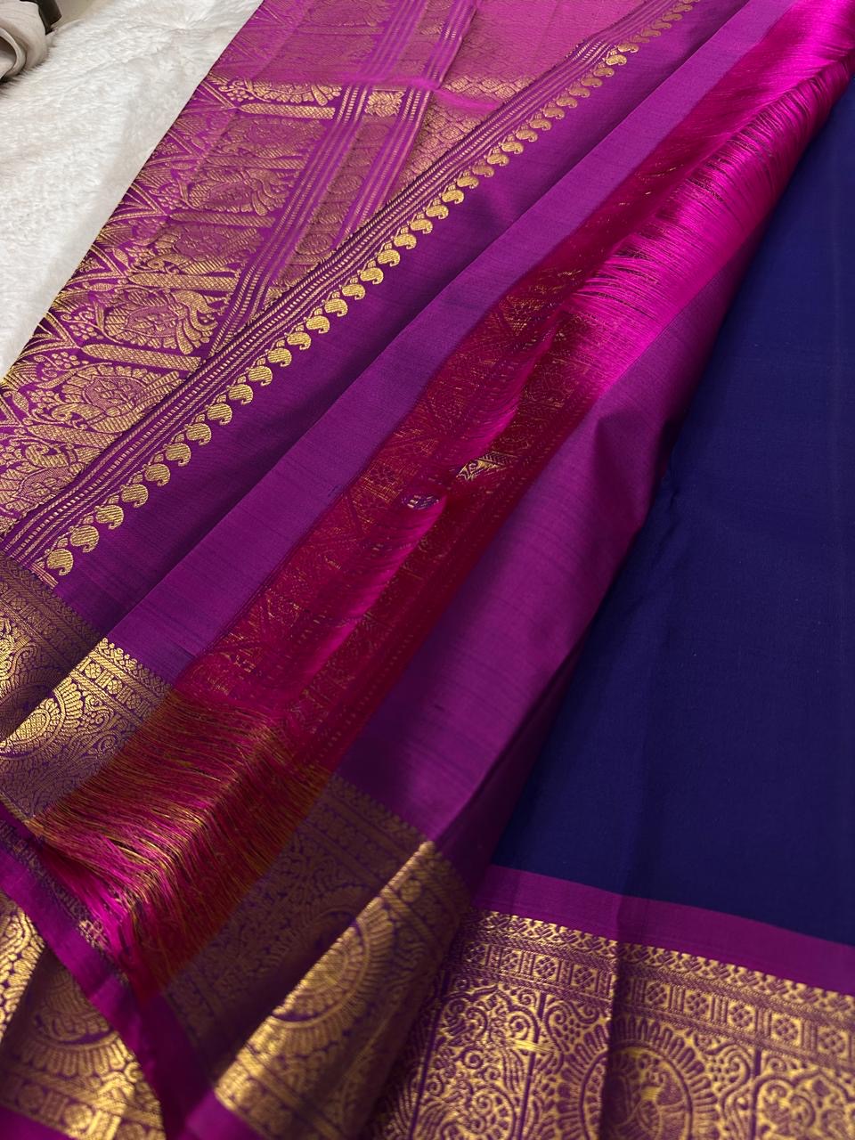 Antique-gold zari peacock medallions and ornamental detailing across the broad Vadamalli border.