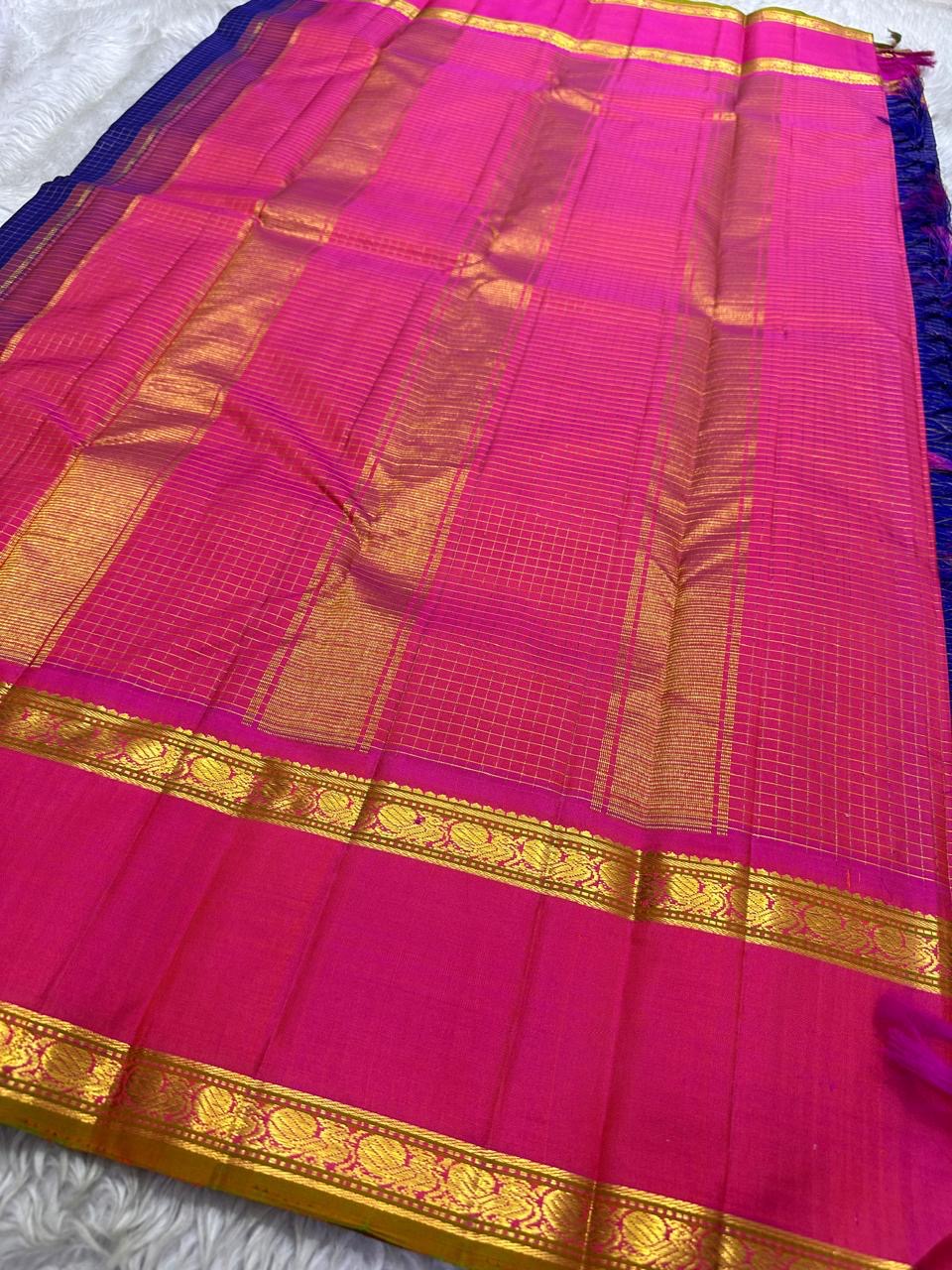 Pure Kanchipuram silk saree flat lay with blue body woven in gold checks and vibrant pink zari border finished with tassels