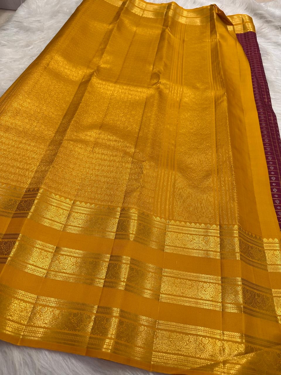 Close-up of tiny gold buttas within the plum purple zari kattam body.