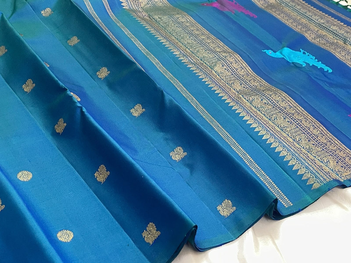 Handwoven peacock blue Kanjivaram silk saree with Kili parrot pallu, zari vine panels and deep green tassels