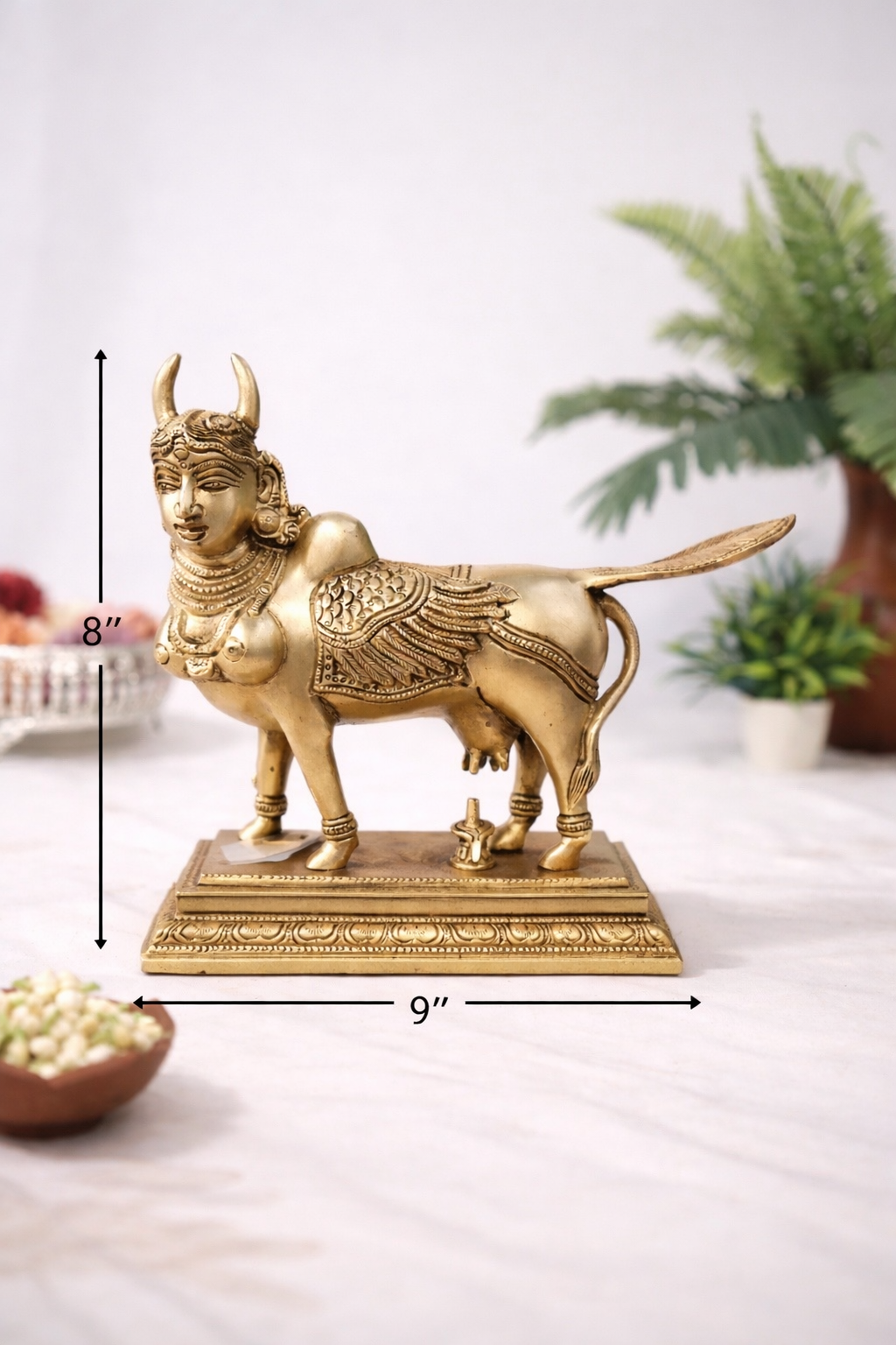 Angled view of ornate pure brass Kamadhenu Hindu traditional idol with antique brass finish and carved base 8 inch