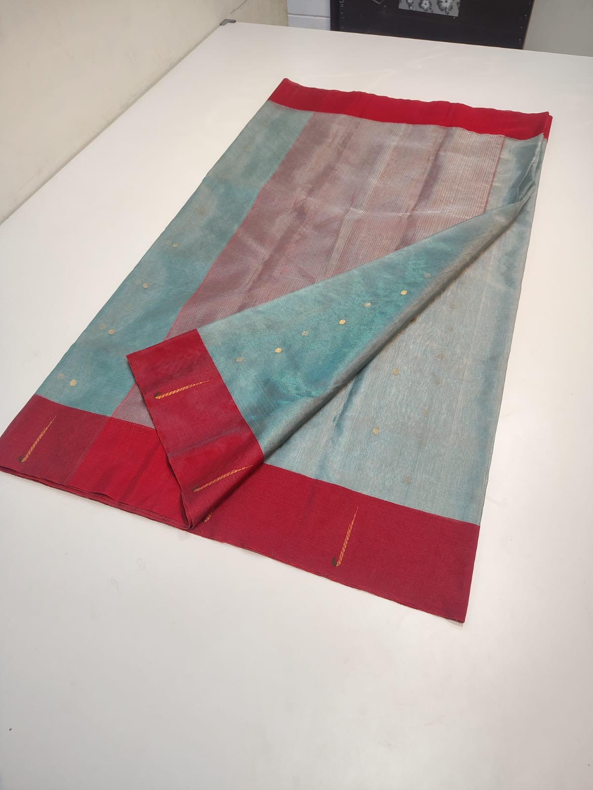 Side view drape of lagoon-blue Chanderi Tissue Silk saree with bright crimson border