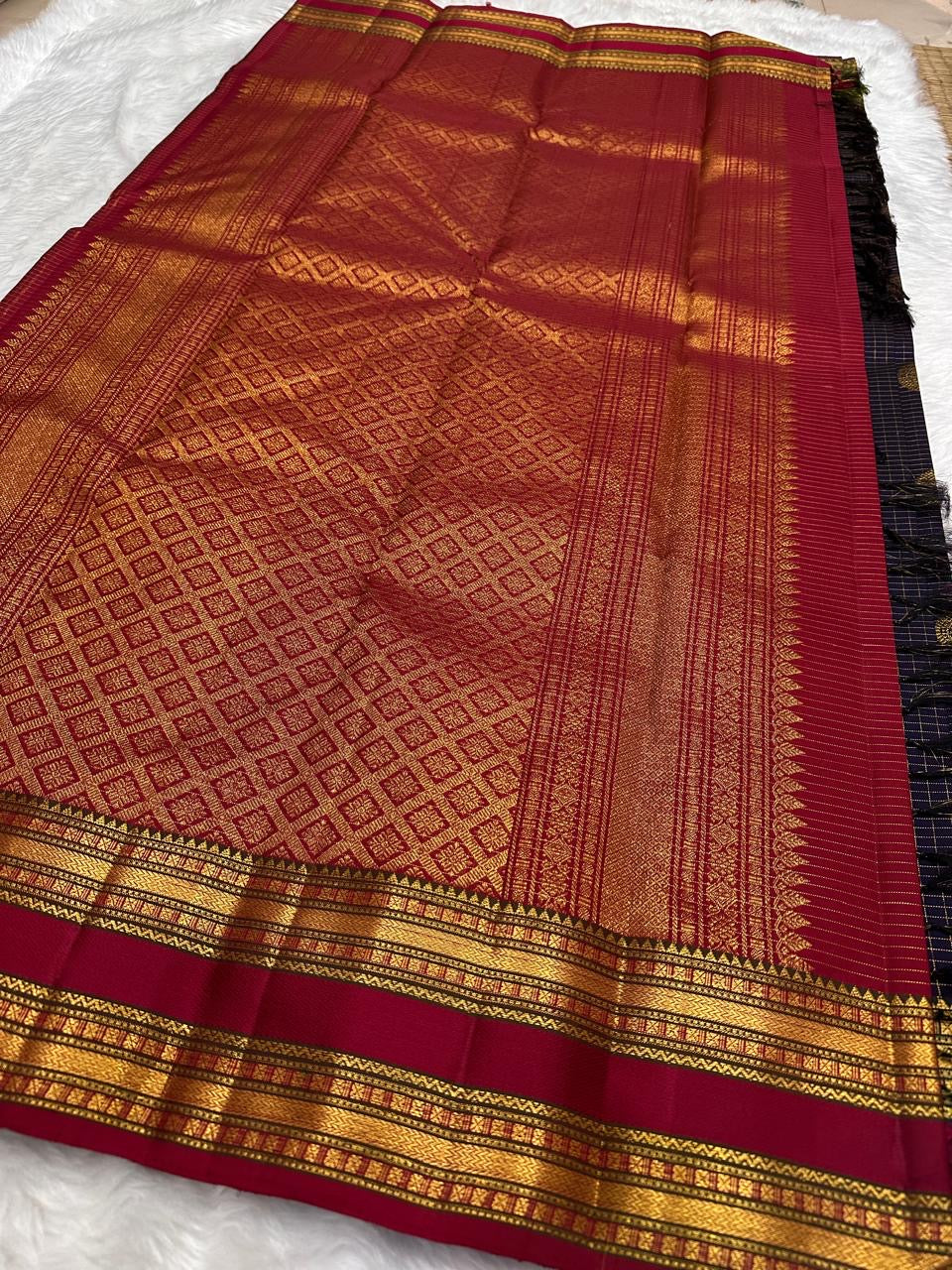 Close view of maroon pallu with gold zari woven bands, tassel edge, and deep plum purple checked Pure Kanchipuram silk saree section
