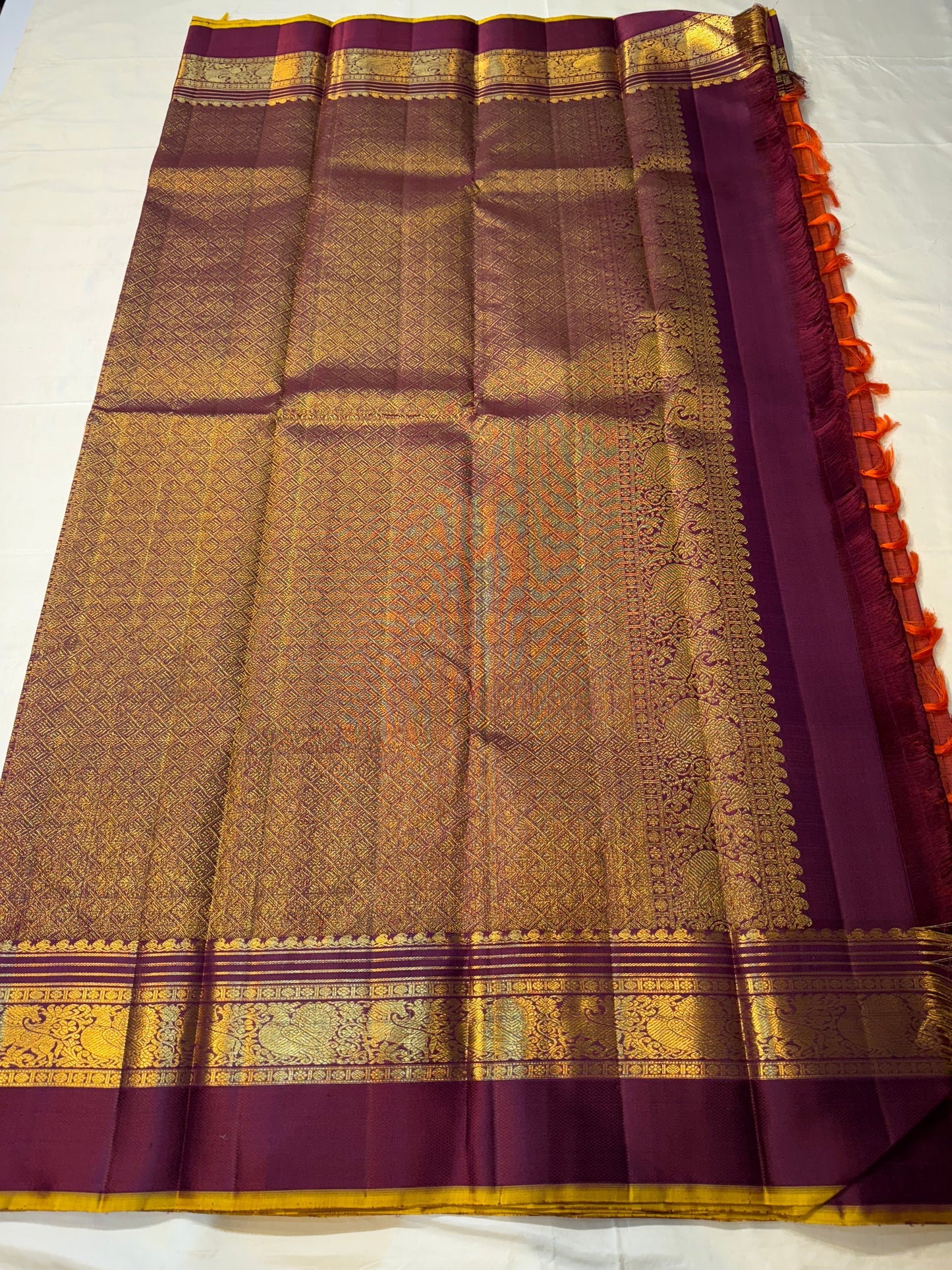 Full pallu layout of deep purple Pure Kanchipuram silk saree with gold zari woven design and orange tassels, available in the USA