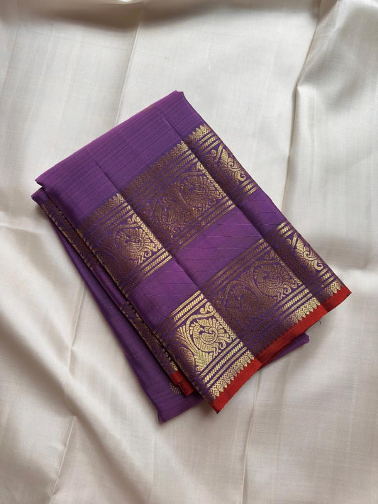 Full spread of violet purple × vermilion orange Kanchipuram silk showing body, twin zari border and grand pallu arrangement