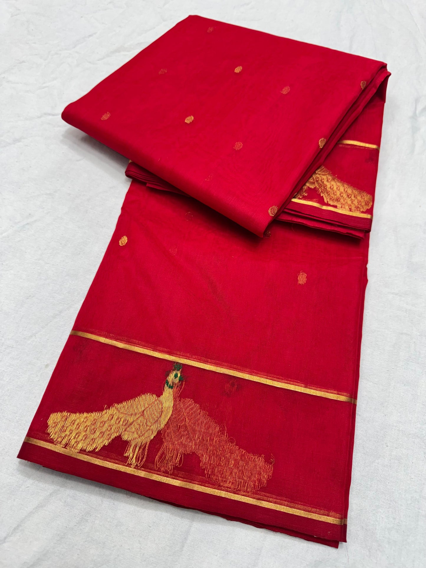 Raspberry red handloom Chanderi Katan Silk saree folded with gold zari border and woven floral accents