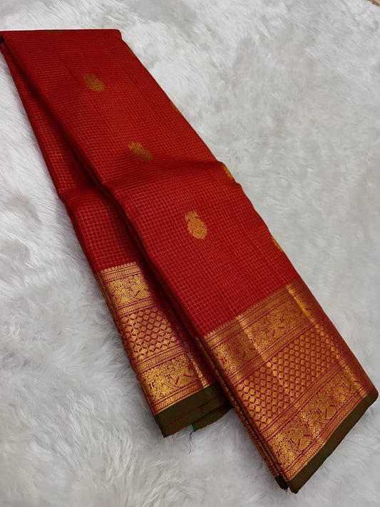 Red oosi kattam Kanchipuram silk saree drape showing zari woven border with green edge