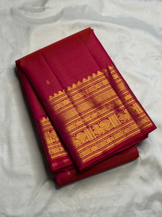 Close view of needle-fine gold Vairaoosi lines across vivid red-pink pure silk.