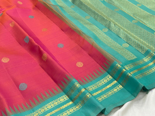 Shot colour tomato red pink Kancheepuram saree body close-up showing Mayil Chakram peacock medallion buttas in coloured silk thread