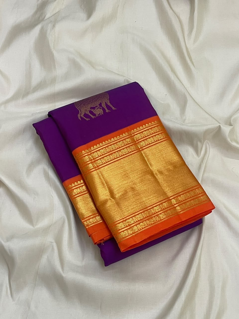 Close view of antique gold cow motifs woven across Royal Purple Kanchipuram silk