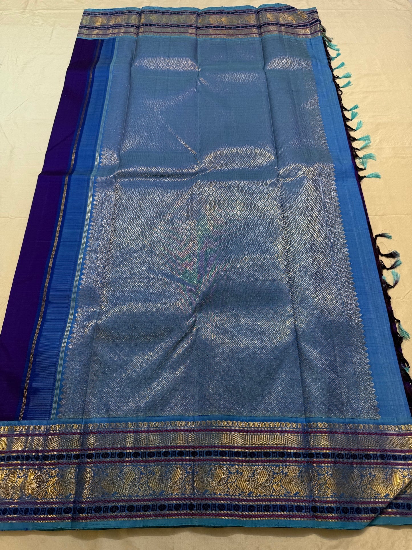 Close-up of peacock and floral zari motifs on the Korvai border, royal purple Kancheepuram saree