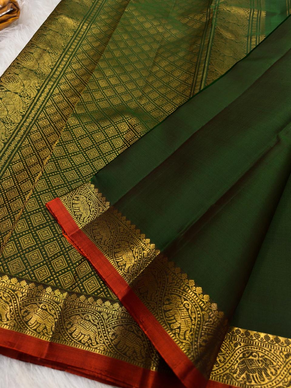 Close view of repeated elephant motifs framed within ornamental classic-gold zari border panels.