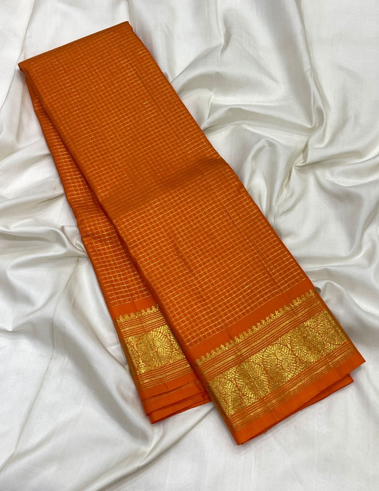 Close view of gold zari grid on Deep Saffron Orange pure silk Kanchipuram saree.