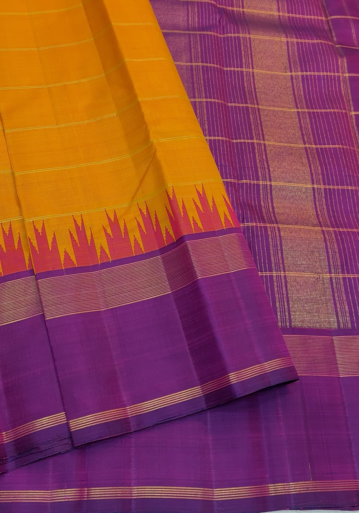 Warm saffron-orange Kanchipuram silk with fine spaced horizontal gold zari lines.