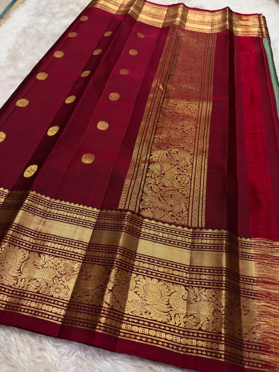 Detail of ornate gold zari Yaanai Ambari elephant procession Butta woven across sage green Kanjipuram silk body