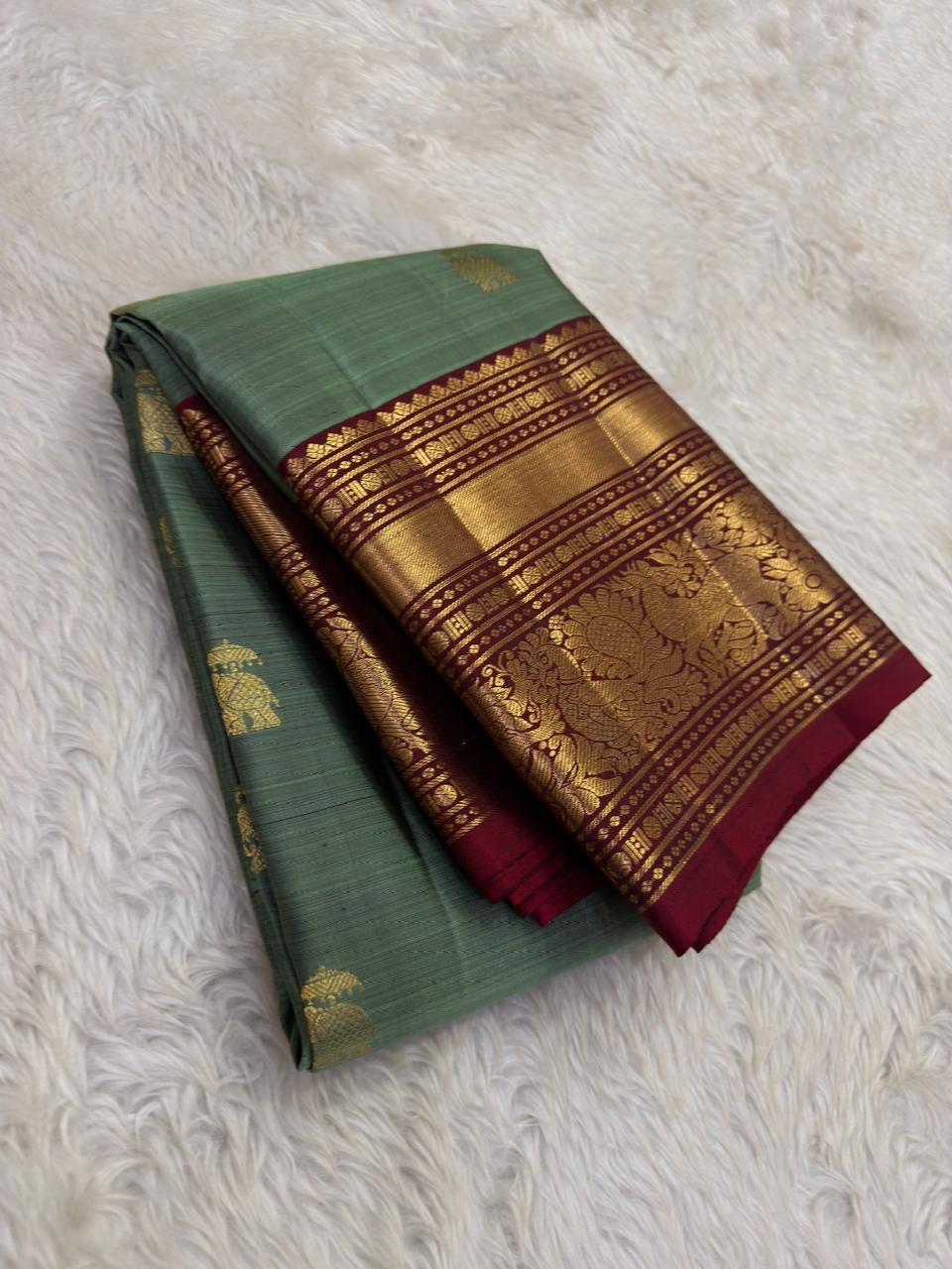 Sage green Kanjivaram saree with burgundy red border and gold zari yaanai ambari butta – detail view