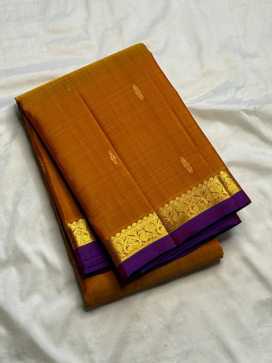 Ponvandu Turmeric Yellow pure silk Kanjivaram Butta saree with antique-gold zari motifs.