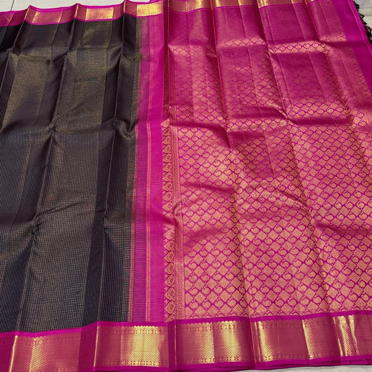 Folded view of the Kanchana Black Handwoven Pure Jari Korvai Kanjivaram Saree with Vairaoosi Kattam Body and Pink Borders.